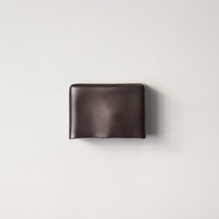 Darkened Brass wall light by Stem Design on a light grey background