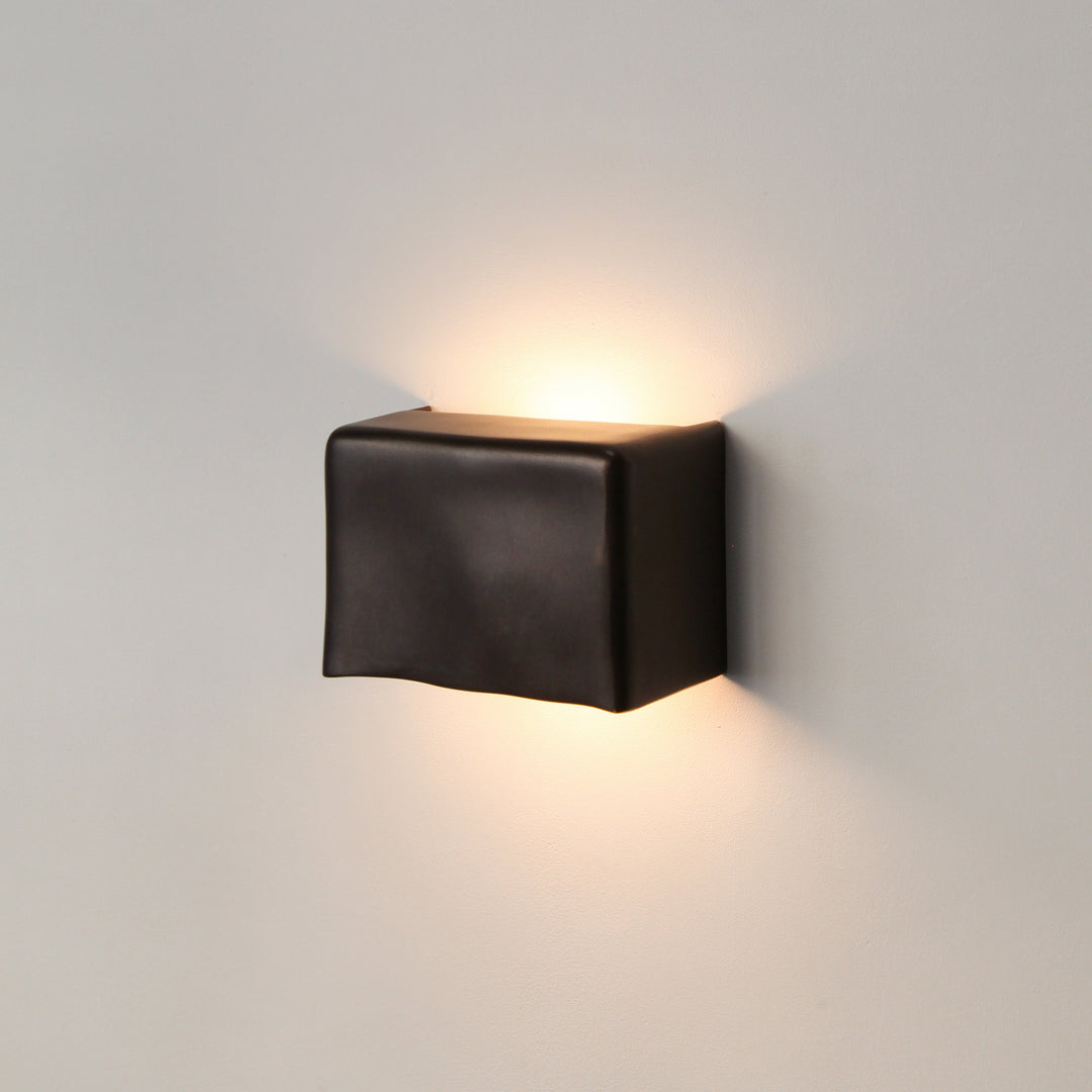Darkened Brass wall light by Stem Design on a light grey background