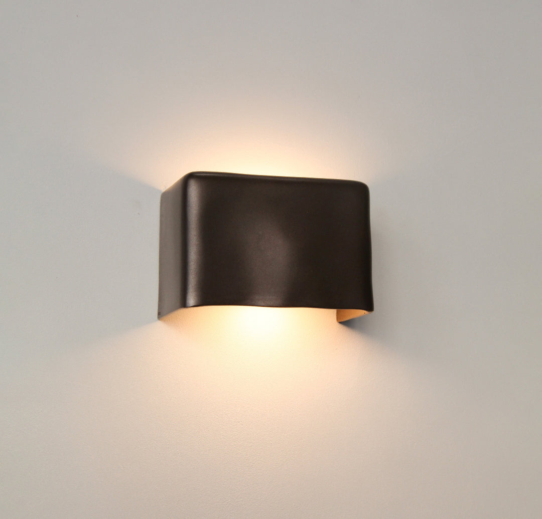 Darkened Brass wall light by Stem Design on a light grey background
