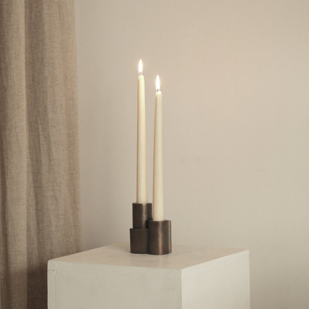 Snug candle holder by stem in darkened brass