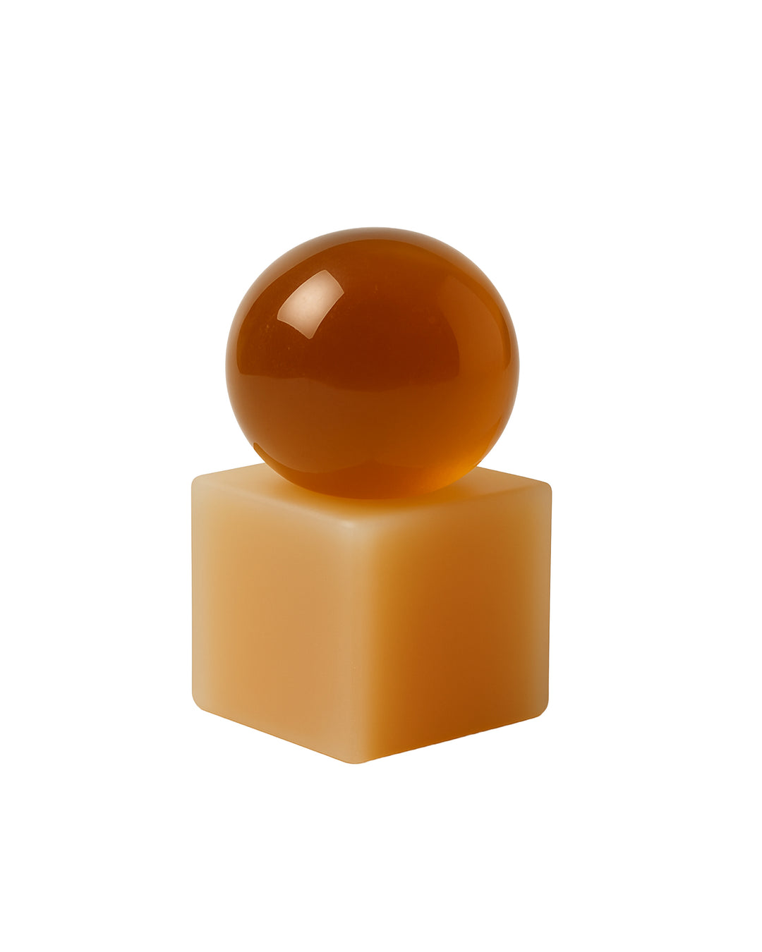 Brown sphere soap on a beige rectangular block against a white background