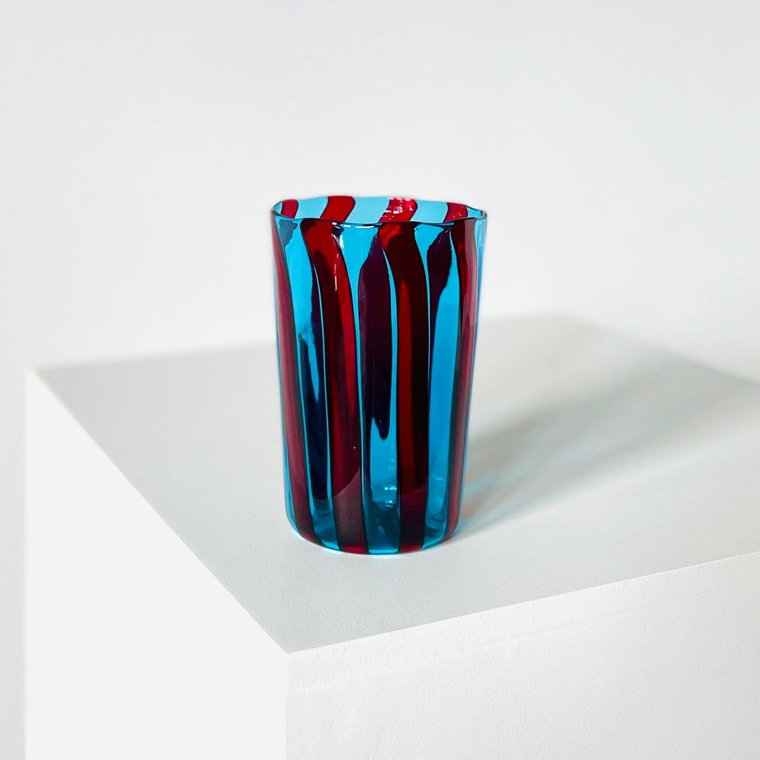 Blue and red striped drinking glass by LAGUNA-B, with vertical bands.