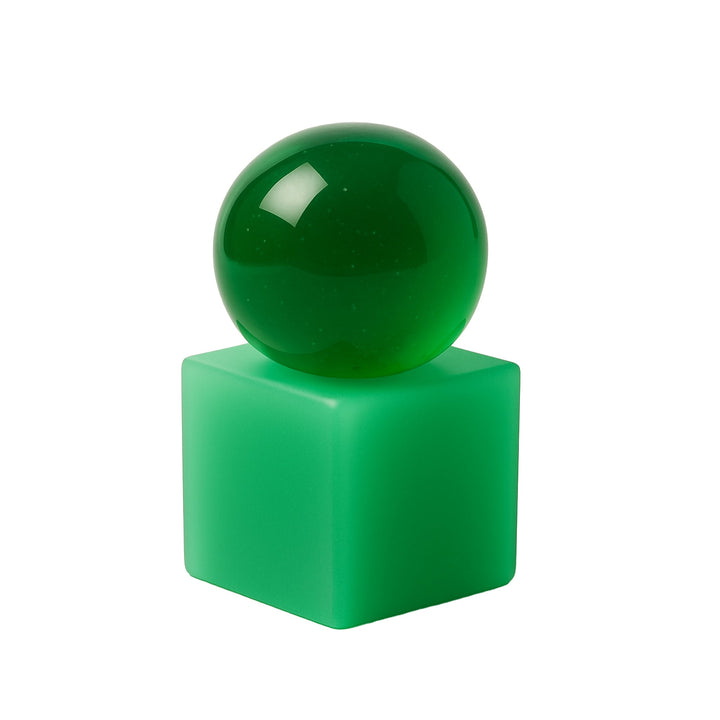 Green sphere soap on a green resin square block against a white background