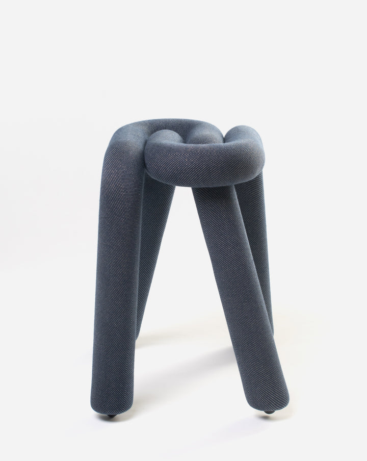 Purple upholstered stool by Moustache with a knot-like design and three rounded legs.