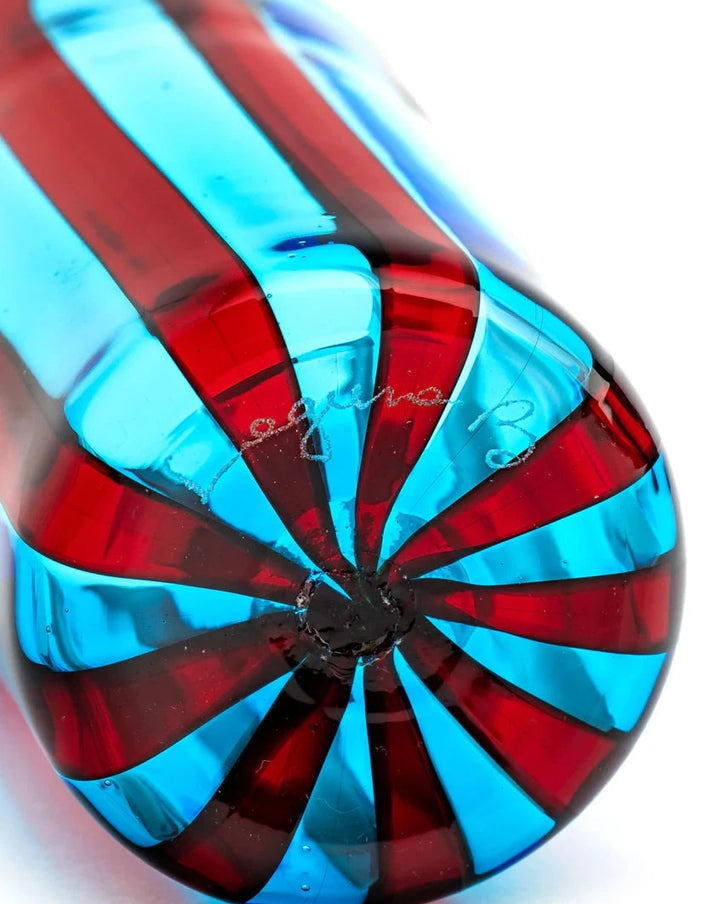 Blue and red striped glass tumbler by Laguna-B, with a swirling pattern at the bottom.