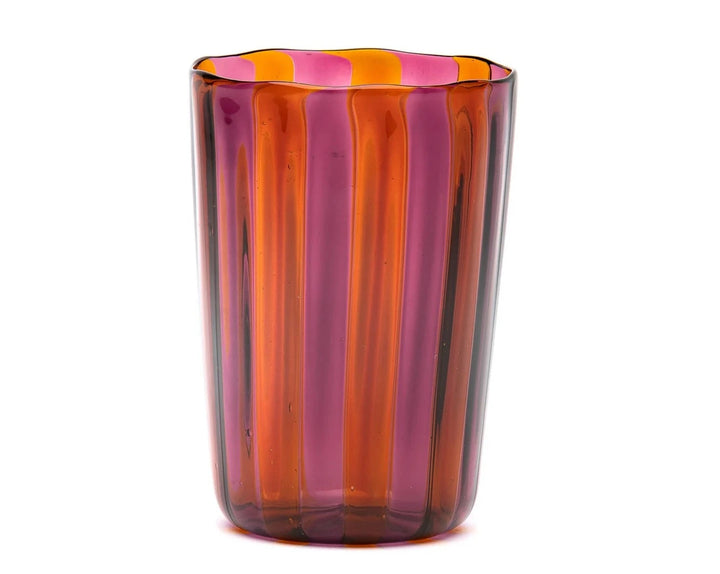 Striped drinking glass by LAGUNA-B with vertical orange and pink bands, and a wavy rim.