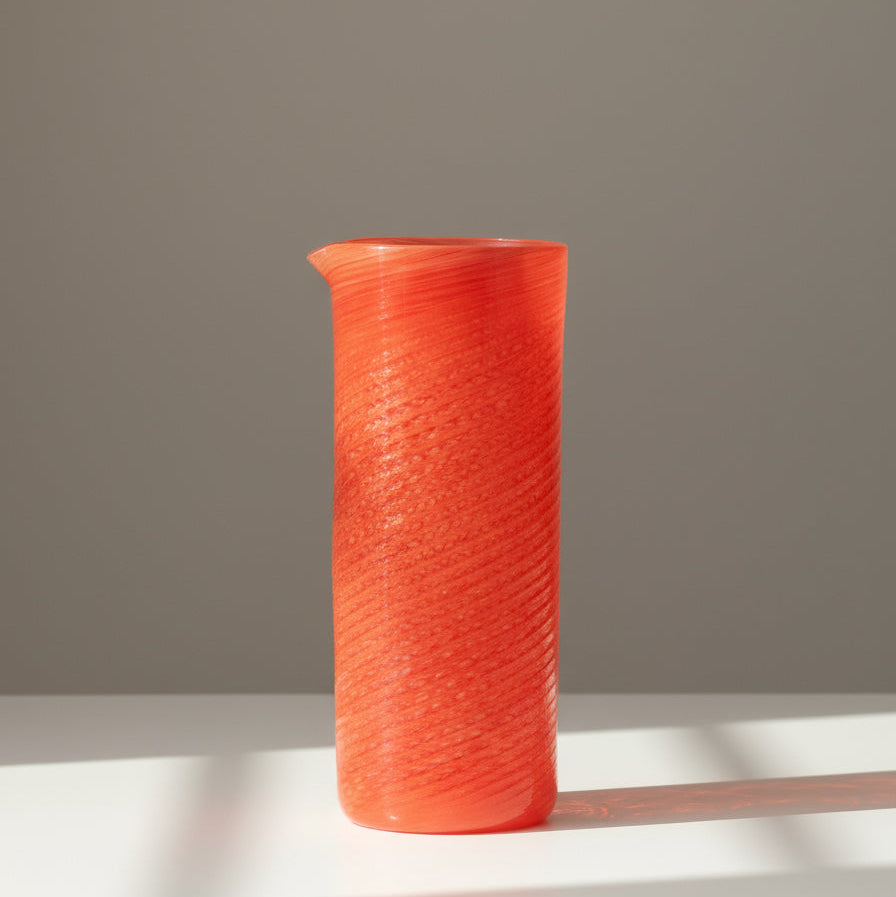 Coral jar by LAGUNA-B with a swirl pattern, standing on a white surface.