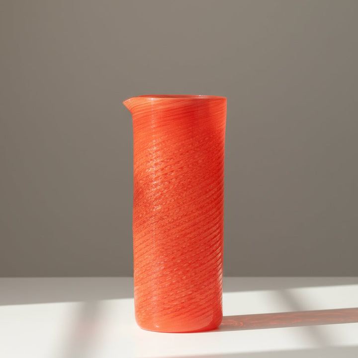 Coral jar by LAGUNA-B with a swirl pattern, standing on a white surface.