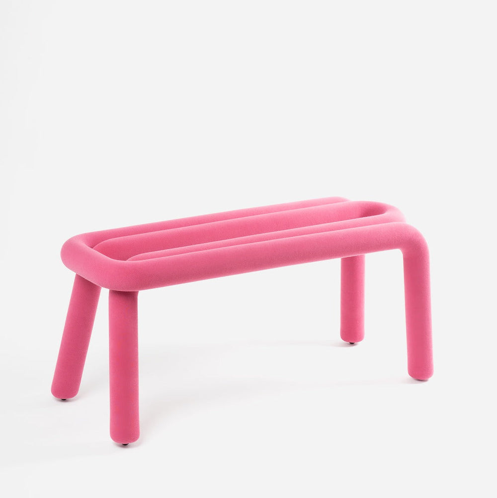Pink bench by Moustache with round legs and fuzzy texture on a white background.
