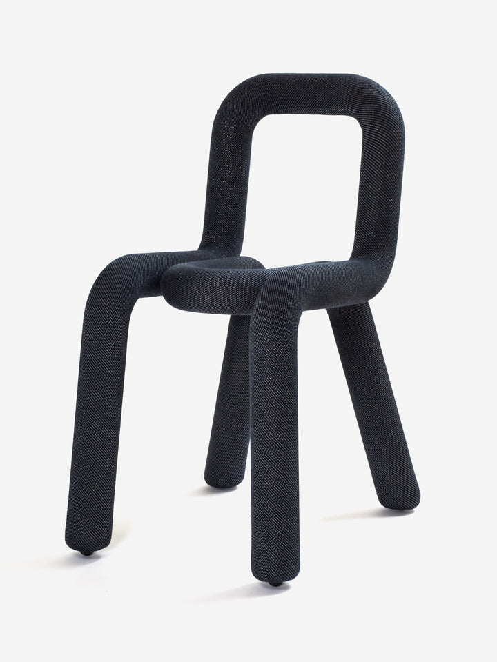 Black upholstered chair by Moustache Paris with rounded tubular frame and denim-like fabric.
