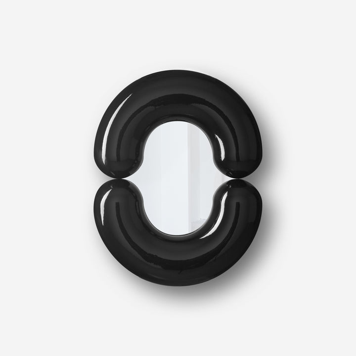 Black wall mirror by Moustache Paris with rounded design and a glossy finish.