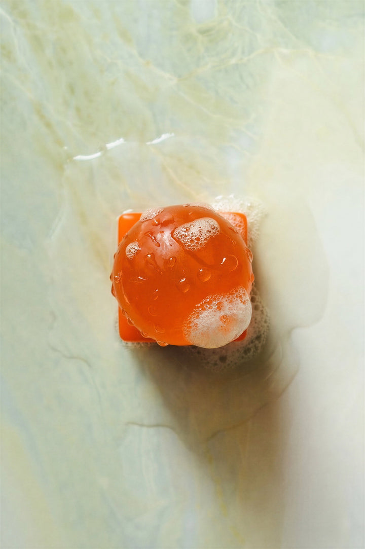 Orange and white soap bar on a textured surface