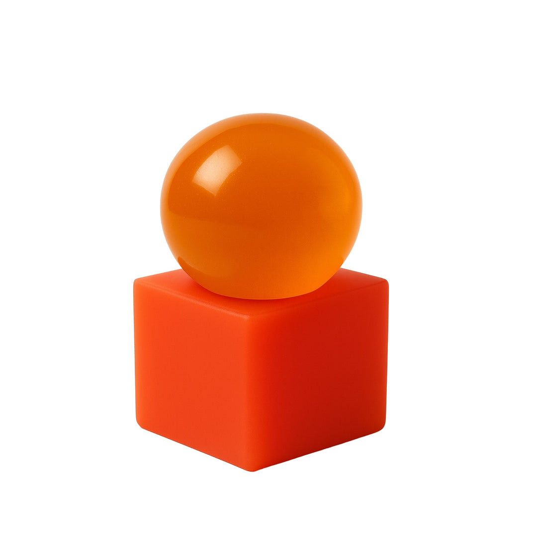 Orange sphere soap on a red resin cube against a white background