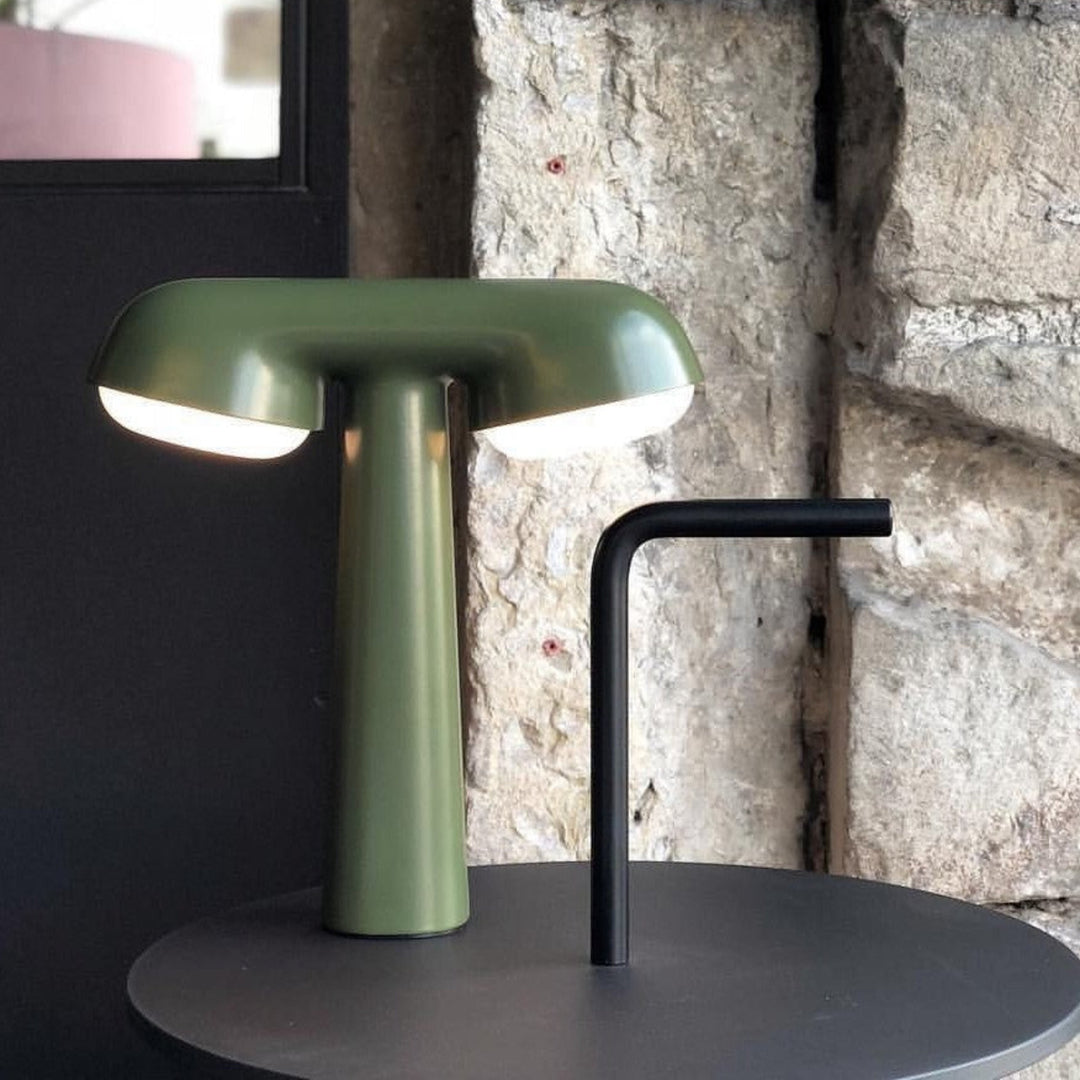 Khaki table lamp by Moustache with two illuminated shades, standing next to a matte black side table.