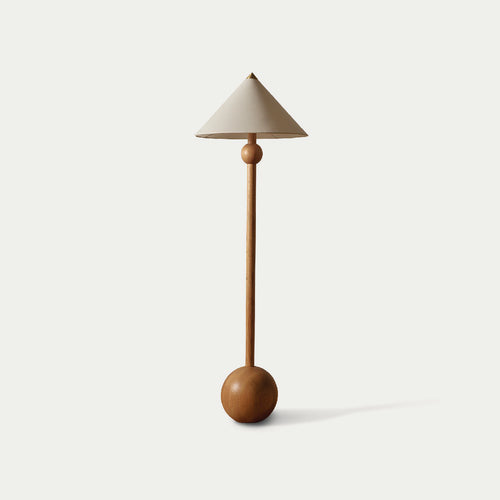 Minimalist floor lamp with a cream shade by McMullin, featuring a wooden stand with a spherical base and middle accent.
