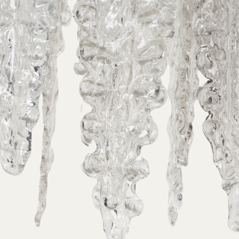 Clear glass pendant light from Venini, with textured icicle details on a neutral backdrop.