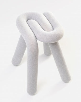 Light grey stool by Moustache Paris with a knotted seat and rounded legs, on a white background.
