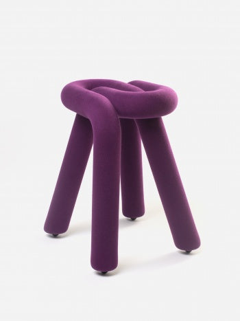 Purple stool with a knot top by Moustache, featuring rounded legs and small caster wheels.