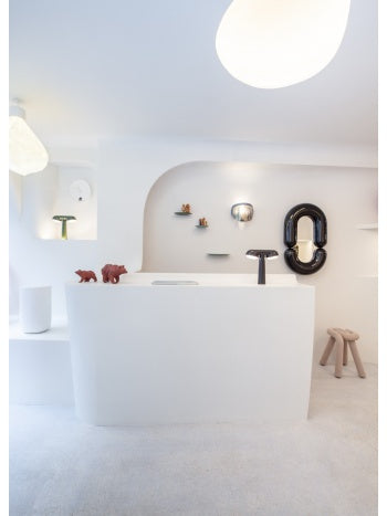 White Zodiac Medium Wall Mirror from Moustache Paris, with a glossy black frame and oval-shaped opening.